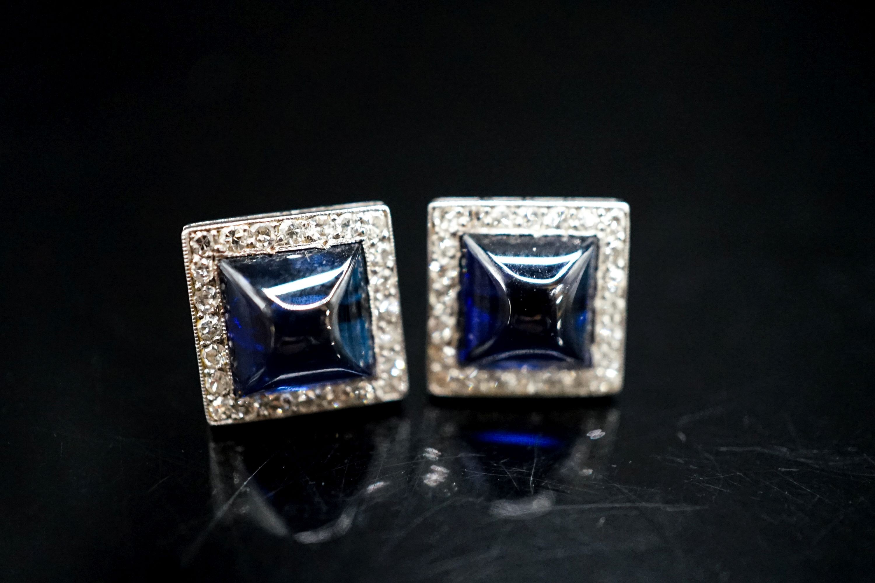 A pair of white metal and blue cabochon set square ear studs with diamond set borders, 11mm, gross weight 5.7 grams.